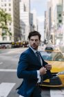Ritratto di un uomo d'affari che attraversa la strada e guarda da parte — Foto stock