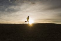 Portrait of young man running in field — Stock Photo