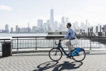 Man on bicycle at New Jersey waterfront with view to Manhattan, USA — Stock Photo