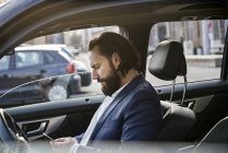 Empresário usando telefone celular em um carro — Fotografia de Stock