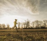 Portrait of young man running in field — Stock Photo