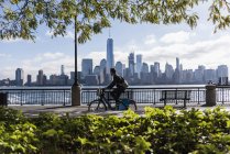 Man riding bicycle at New Jersey waterfront with view to Manhattan, USA — Stock Photo