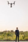 Ritratto di uomo d'affari in piedi all'aperto con drone volante — Foto stock