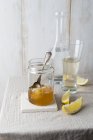 Vaso di miele con nido d'ape e bicchiere d'acqua — Foto stock