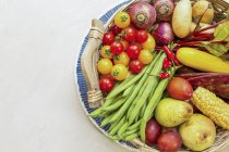 Tazón de frutas y verduras frescas sobre fondo blanco - foto de stock