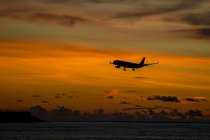 Indonesia, Bali, airplane in the sky and sunset over the ocean — Stock Photo
