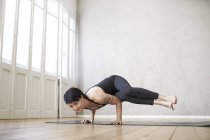 Donna che pratica yoga sul pavimento in legno — Foto stock