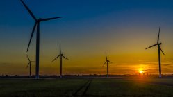 Закат пейзаж с ветряными мельницами на поле — стоковое фото