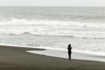 Indonésia, Java, mulher caminhando na costa oceânica — Fotografia de Stock