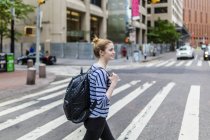 Portrait of young woman walking at street — Stock Photo