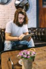 Stylish hipster man using digital tablet in coffee shop — Stock Photo