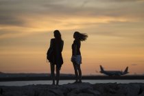 Indonesien, Bali, zwei Frauen, die den Sonnenuntergang über dem Ozean beobachten — Stockfoto