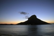 Далеких вид на острів силует на заході сонця — стокове фото