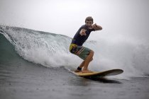 Indonesia, Java, hombre surfeando y posando en el océano - foto de stock