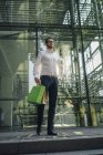 Портрет бизнесмена, держащего сумки возле здания — стоковое фото