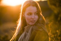 Woman standing in nature at sunset — Stock Photo