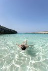 Испания, Менхенгладбах, пляж Талайер, девушка плавает в бирюзовой воде — стоковое фото