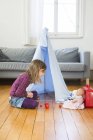 Bambina che gioca a caffè con i giocattoli sul pavimento a casa — Foto stock