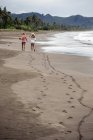 Indonesia, Java, two women walking on the beach — Stock Photo