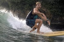 Indonesia, Java, hombre confiado surfeando en el océano - foto de stock