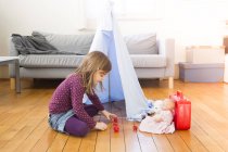 Bambina che gioca a caffè con i giocattoli sul pavimento a casa — Foto stock