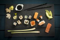 Vista dall'alto del sushi su sfondo scuro servito con salsa di soia — Foto stock
