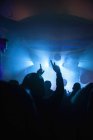 Толпа веселится на концерте в темноте — стоковое фото