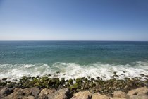 Денного зору кам'янистий пляж і далеких морський пейзаж — стокове фото