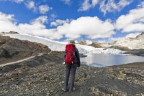Peru, Andes, Cordillera Blanca, Huascaran National Park, tourist standing at shore of Pastoruri glacier lake — Stock Photo