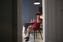 Сидящая на кухне очаровательная молодая женщина — стоковое фото