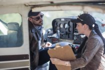Zwei junge Piloten inspizieren ein Leichtflugzeug — Stockfoto