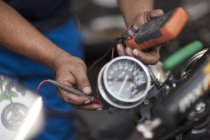 Mécanicien de moto en atelier tenant un tensiomètre — Photo de stock