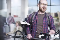 Homme occasionnel quittant le bureau avec son vélo — Photo de stock