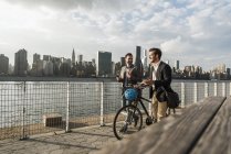 Dois homens de negócios com bicicleta andando ao longo de East River, Nova York, EUA — Fotografia de Stock