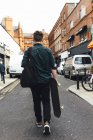 Visão traseira do jovem com skate em Dublin, Irlanda — Fotografia de Stock