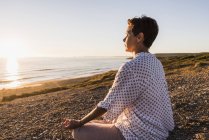 Mulher meditando na praia em Finistere da Bretanha, península de Crozon, França — Fotografia de Stock