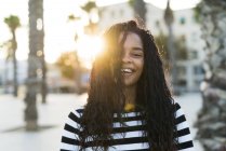 Retrato de la joven feliz en la plaza al atardecer - foto de stock