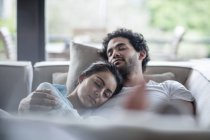 Giovane coppia che dorme su un divano — Foto stock