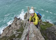Uk, cornwall, lächelnde Frau klettert auf Kommandokamm — Stockfoto