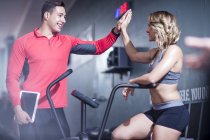 Fitness sfiducia alto cinque con la donna sulla macchina esercizio — Foto stock