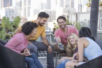 Amici che guardano smartphone alla festa sul tetto, Los Angeles, Stati Uniti — Foto stock