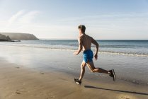 Giovane che corre sulla spiaggia, Francia, penisola di Crozon — Foto stock