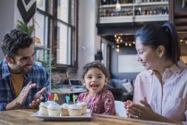 Famiglia felice al tavolo della cucina con torte tazza di compleanno — Foto stock
