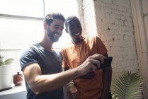 Due giovani uomini felici con il cellulare in un loft — Foto stock