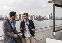 Zwei lächelnde Geschäftsleute im Gespräch auf der Fähre auf dem East River, New York City, USA — Stockfoto