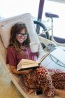Donna sorridente che legge un libro a casa — Foto stock