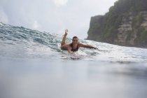 Indonesien, bali, Frau liegt auf Surfbrett im Meer — Stockfoto