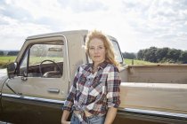 Retrato de mujer rubia fresa apoyada contra furgoneta - foto de stock