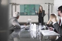 Empresária segurando apresentação na frente da equipe — Fotografia de Stock