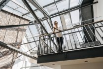 Empresario de pie en el piso superior en la oficina - foto de stock
